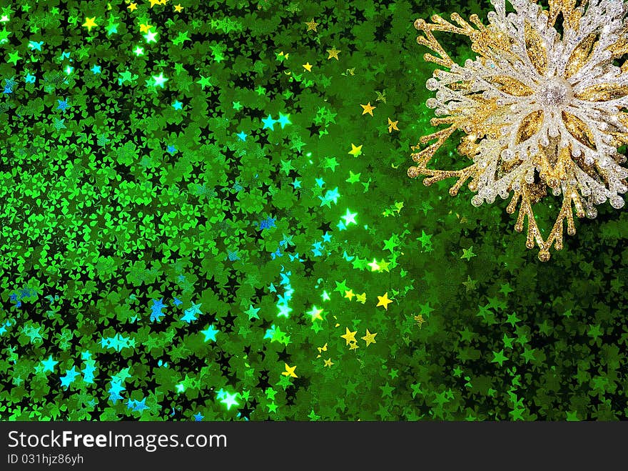 Gold snowflake on a green starry background. Gold snowflake on a green starry background.