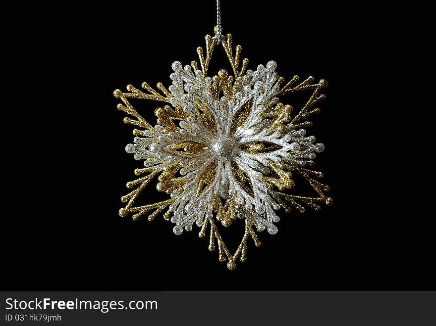 Silver-golden snowflake on black