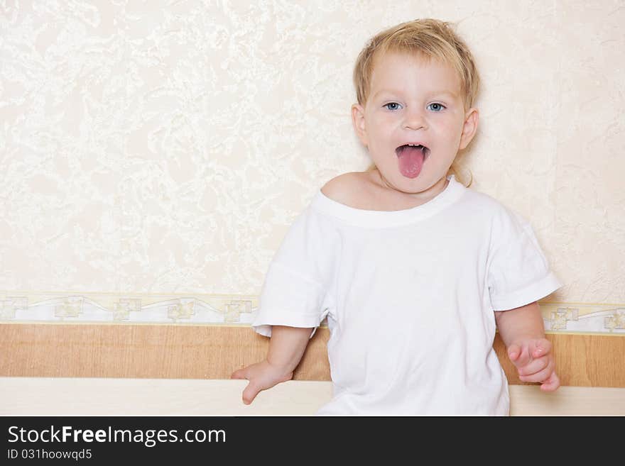 Child Showing His Tongue On Room Background