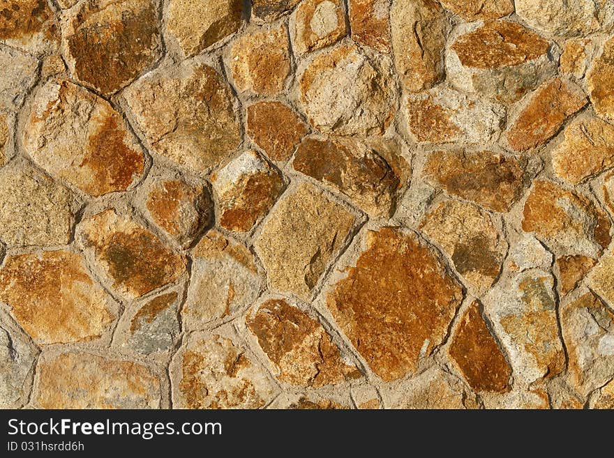 Close up of an orange tinted stone wall background