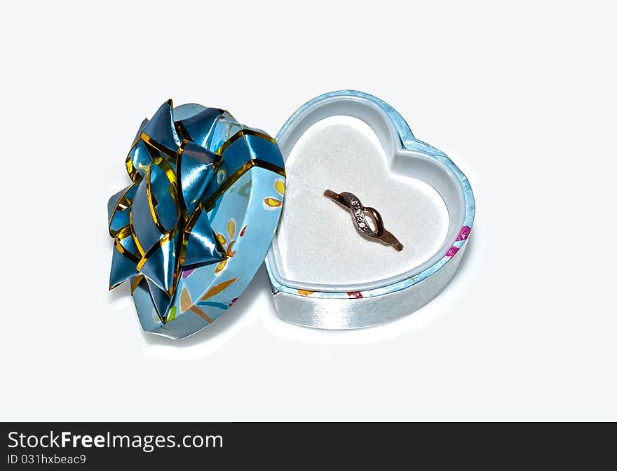 A golden ring in a heart-shaped box. A golden ring in a heart-shaped box