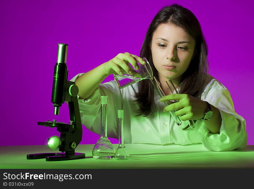 Young school girl playing with tubes and a microscope. Young school girl playing with tubes and a microscope