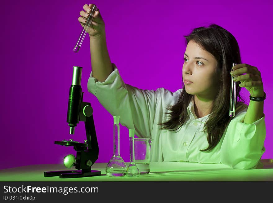 Young school girl playing with tubes and a microscope. Young school girl playing with tubes and a microscope