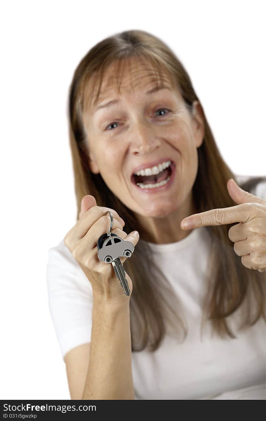 Happy woman to point at her own car key and car on a key ring in the hand, isolated on white. Happy woman to point at her own car key and car on a key ring in the hand, isolated on white