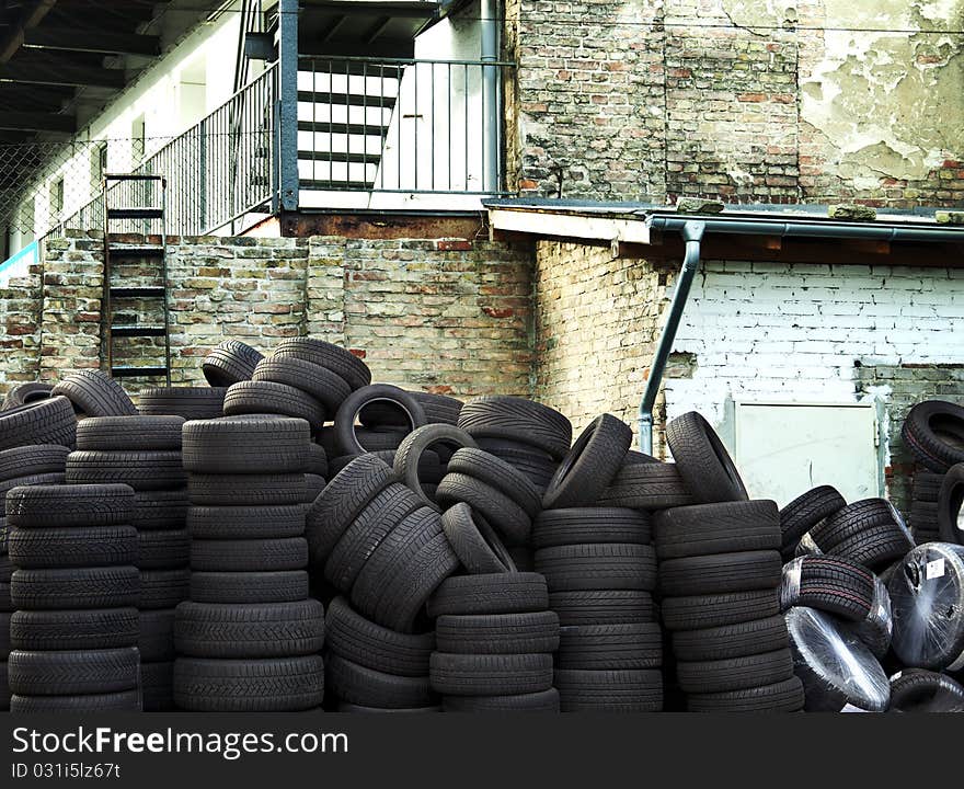 Wall of old car tires with old Brick Wall in the background