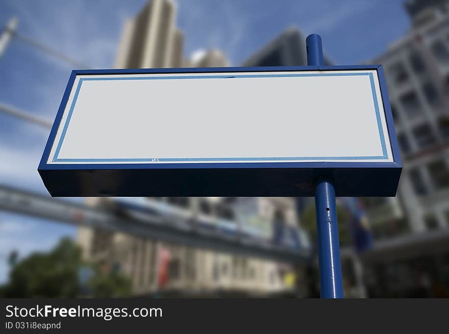 Blank white commercial store sign on blue pole day time city on background. Blank white commercial store sign on blue pole day time city on background