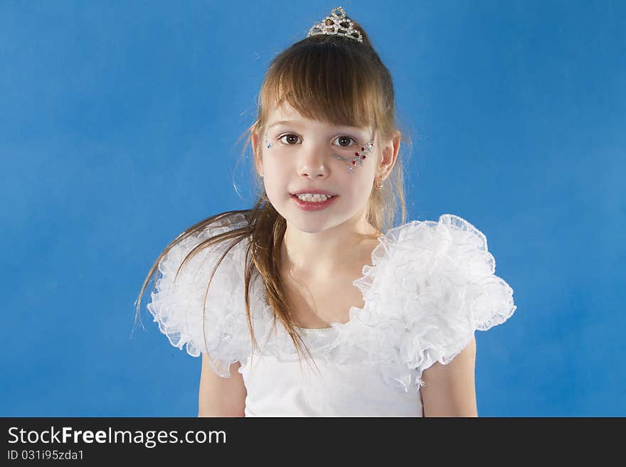 Girl the princess in a white dress opposite to a blue background. Girl the princess in a white dress opposite to a blue background