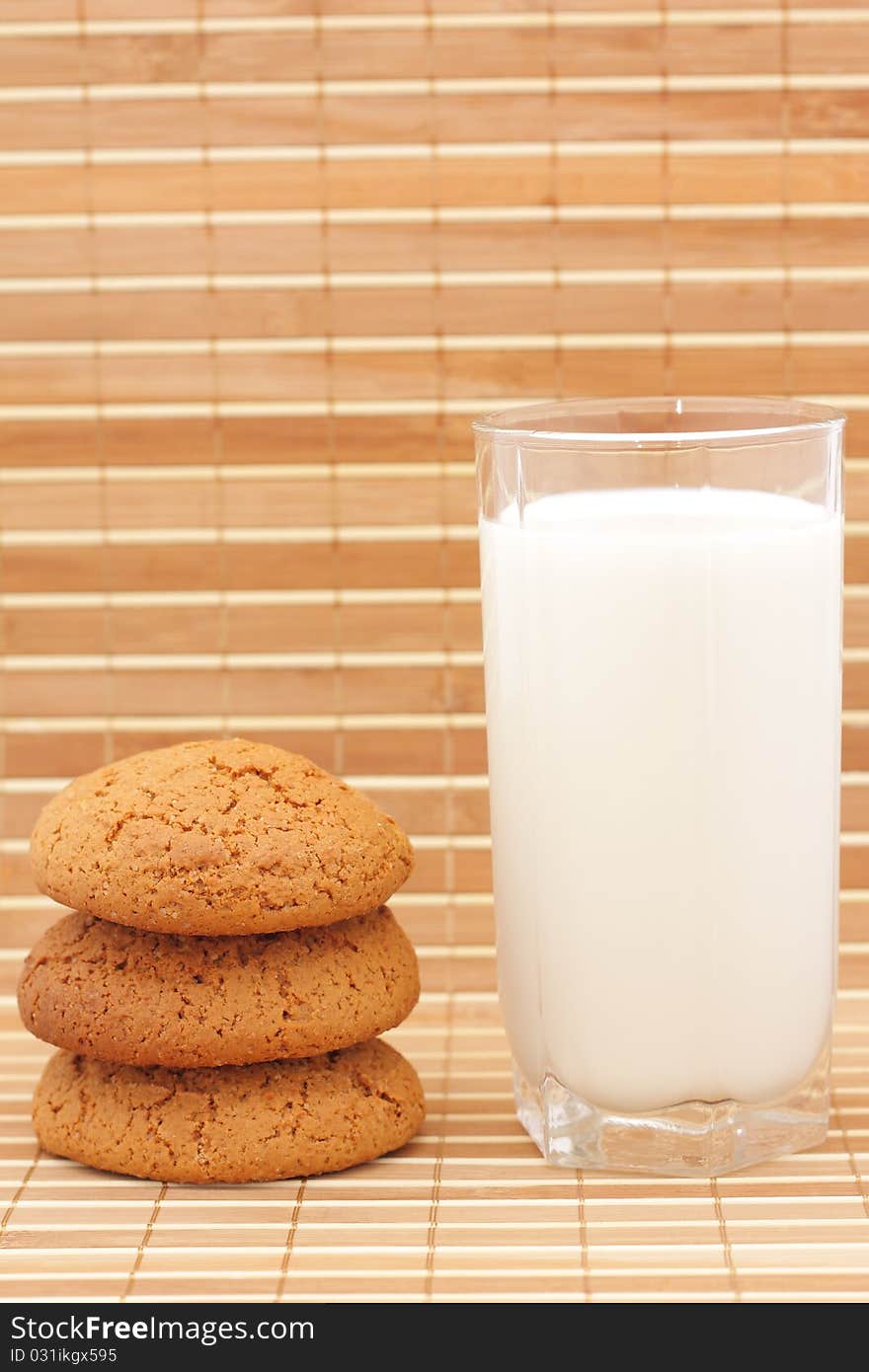 Oatmeal cookies and milk in a glass substrate at a straw