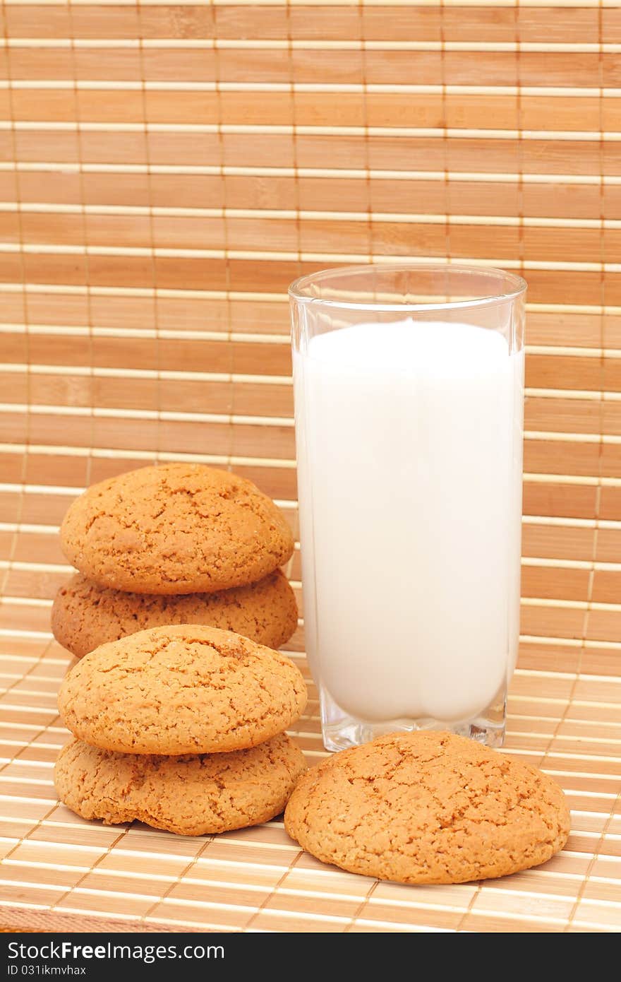 Oatmeal cookies and milk in a glass substrate at a straw