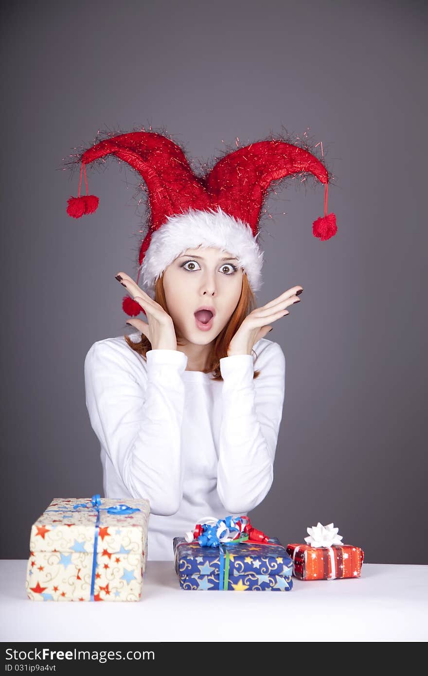 Surprised red-haired girl in christmas cap