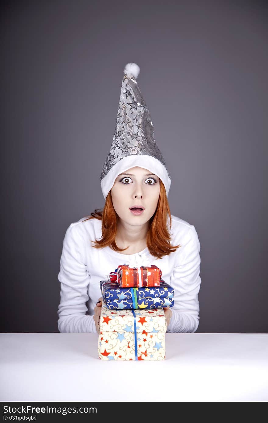 Surprised red-haired girl in christmas cap