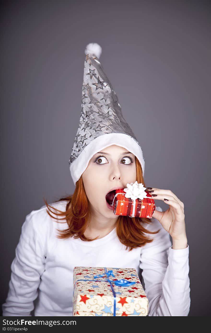 Surprised red-haired girl in christmas cap