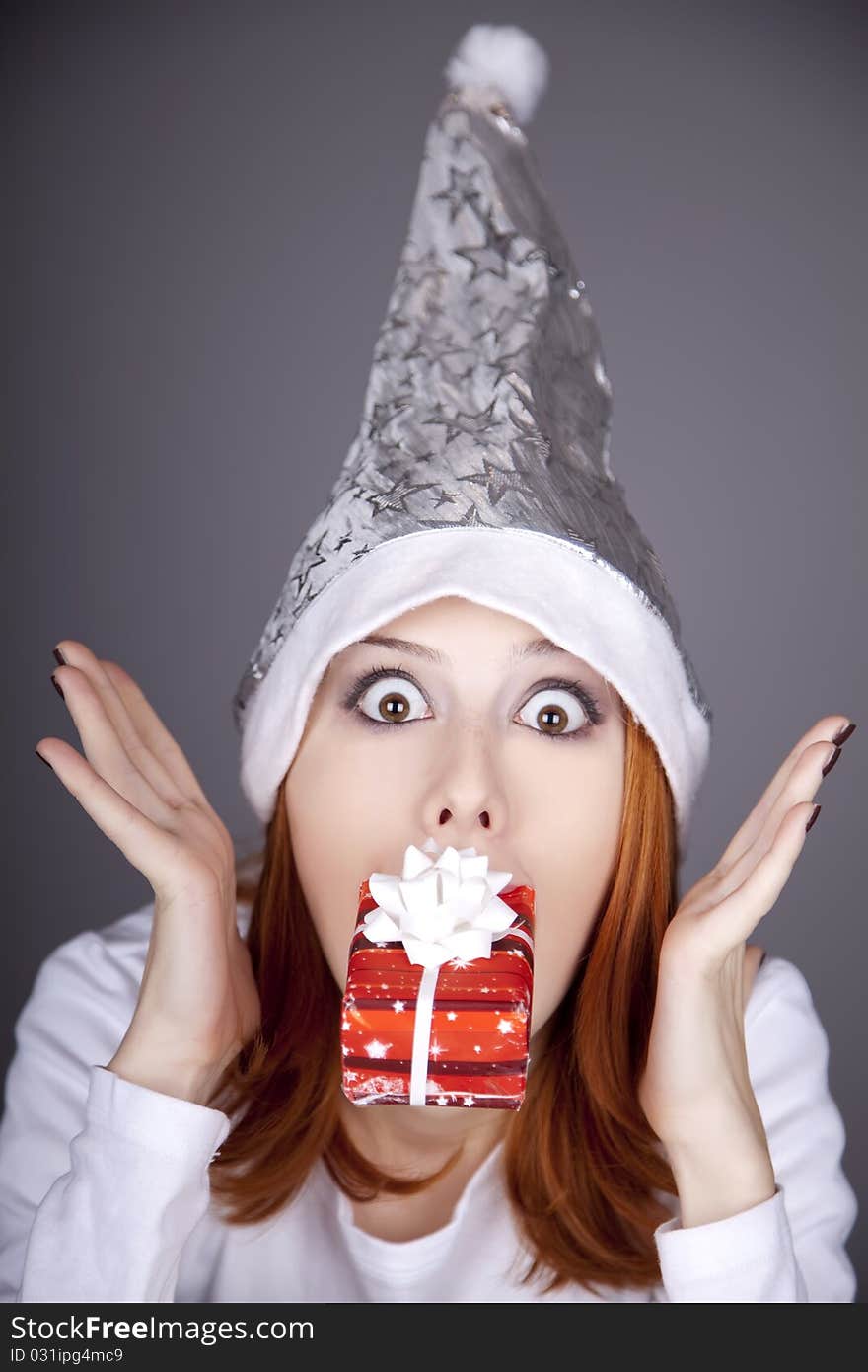 Surprised red-haired girl in christmas cap