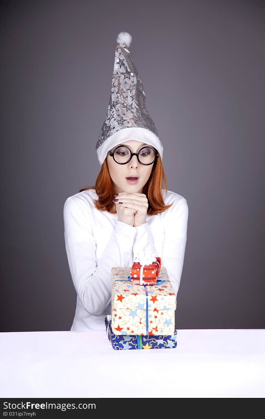 Surprised red-haired girl in christmas cap