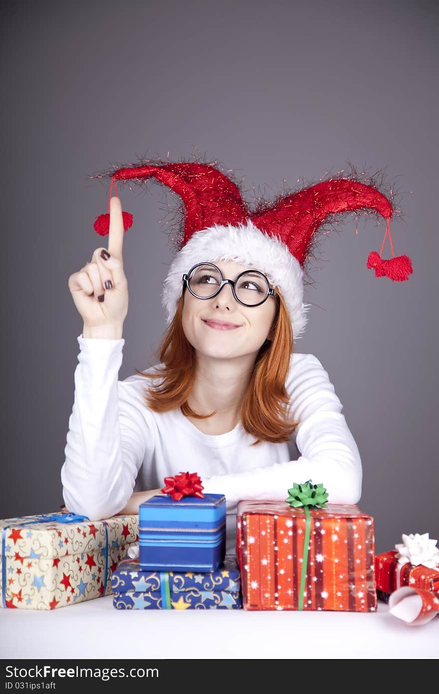 Surprised red-haired girl in christmas cap