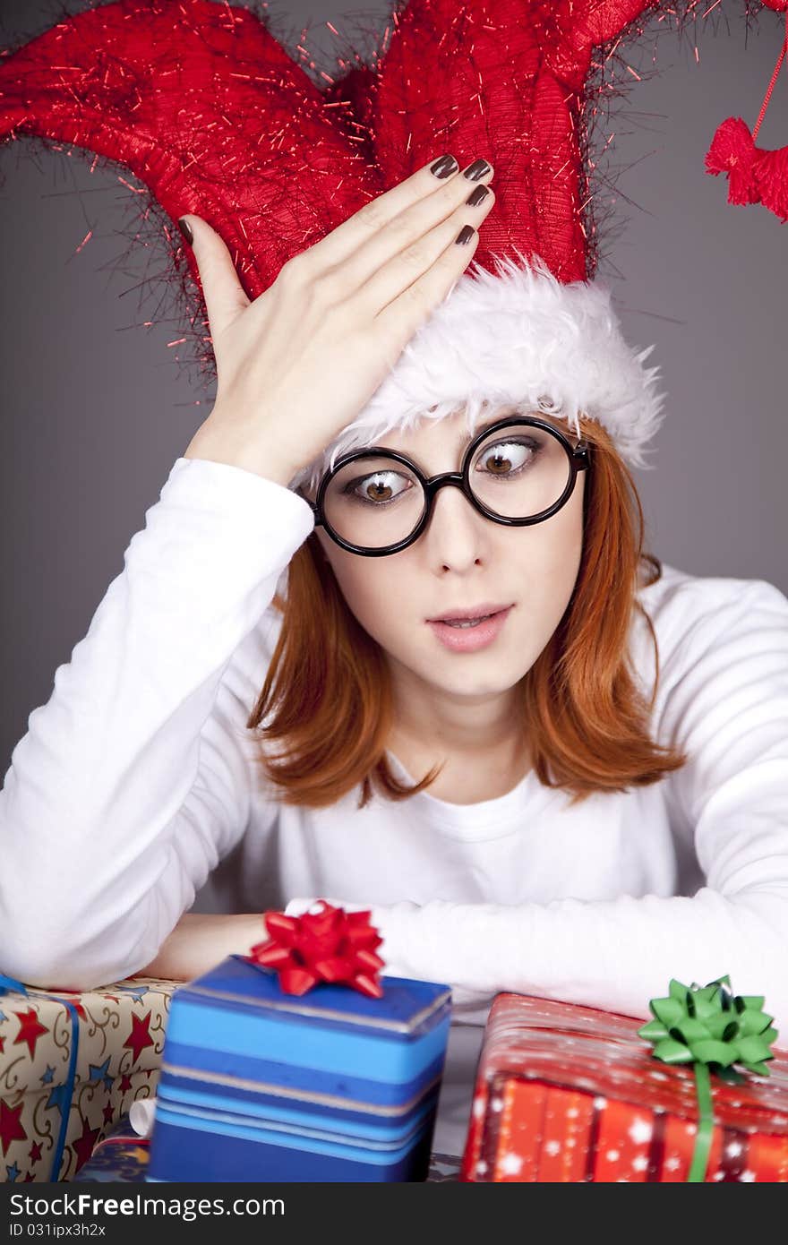 Surprised red-haired girl in christmas cap