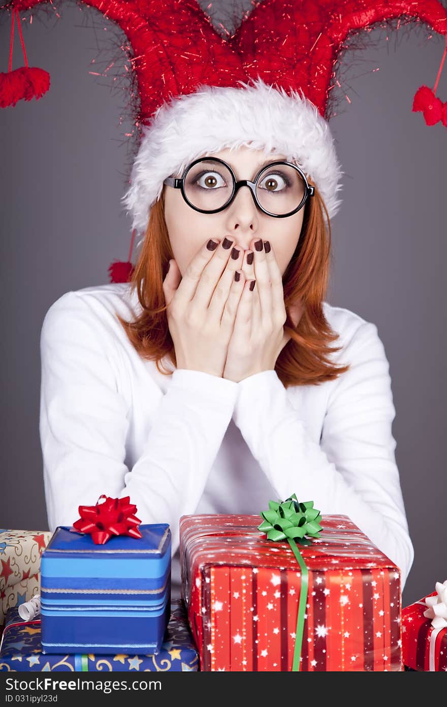 Surprised red-haired girl in christmas cap