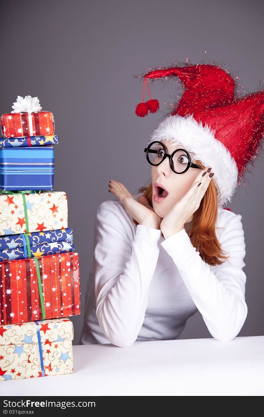 Surprised red-haired girl in christmas cap