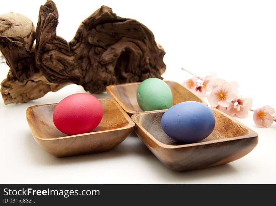 Colored eggs in the wood bowl with flower. Colored eggs in the wood bowl with flower