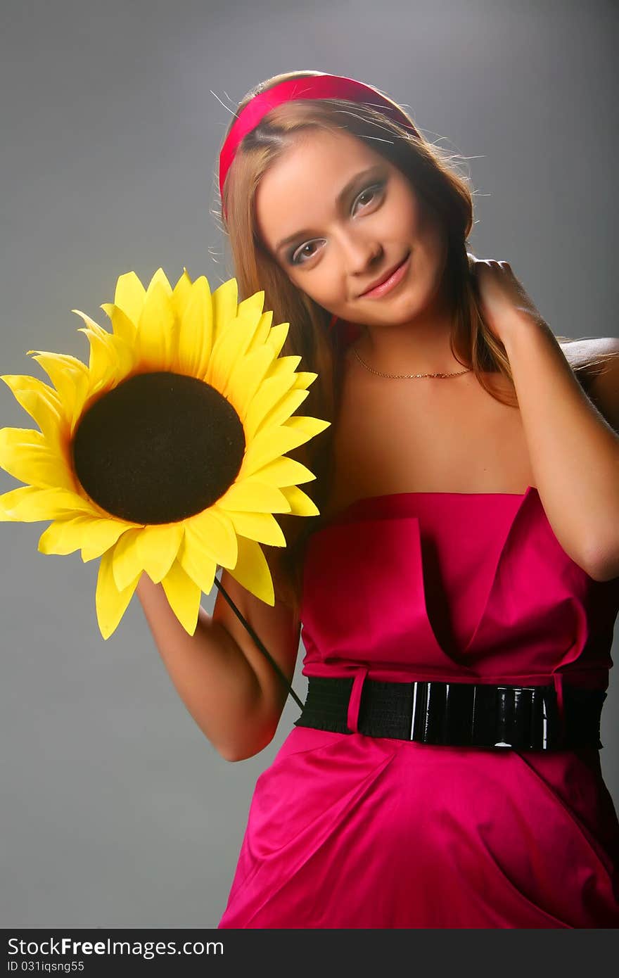 Girl With A Sunflower In A Pink Dress On A Grey