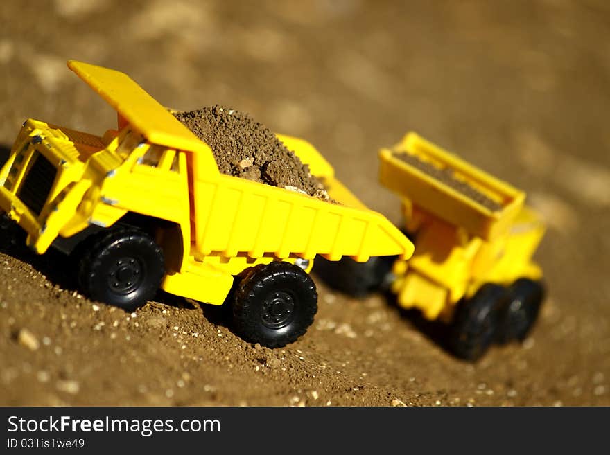 Tiny, toy truck and tractor working with dirt. Tiny, toy truck and tractor working with dirt.