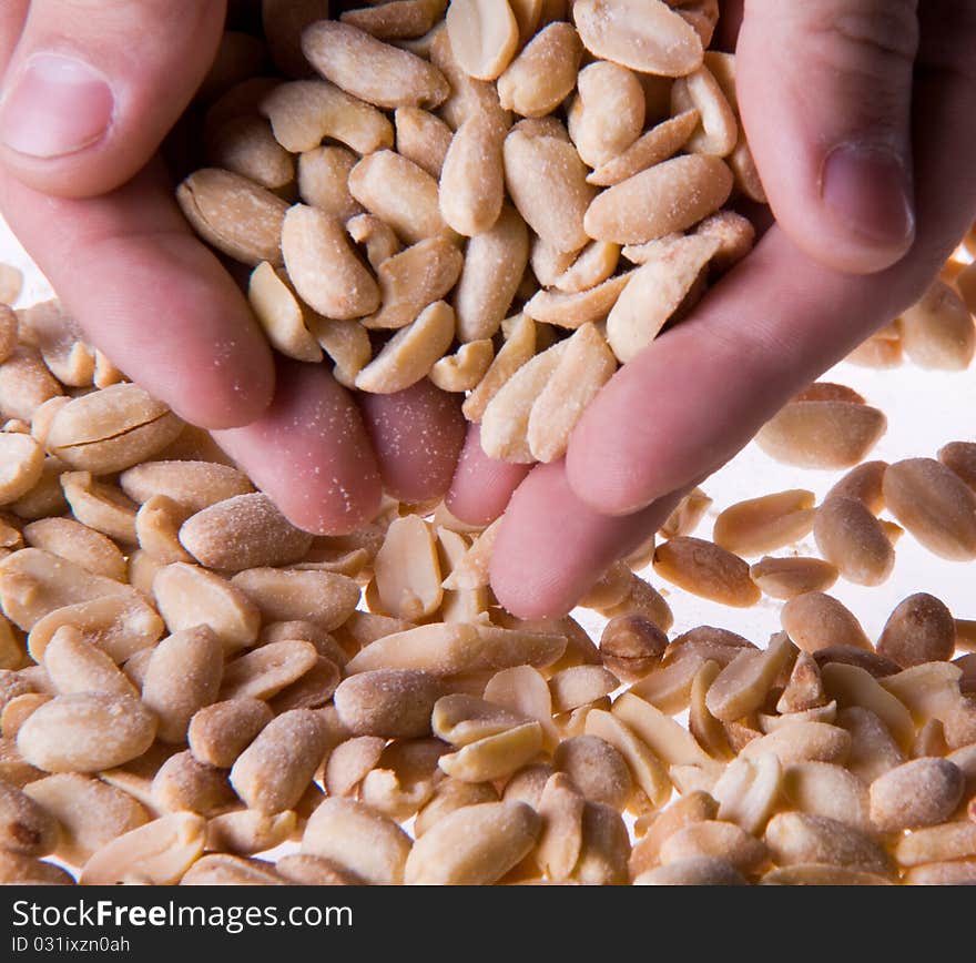 Hand holding a handful of salted peanuts