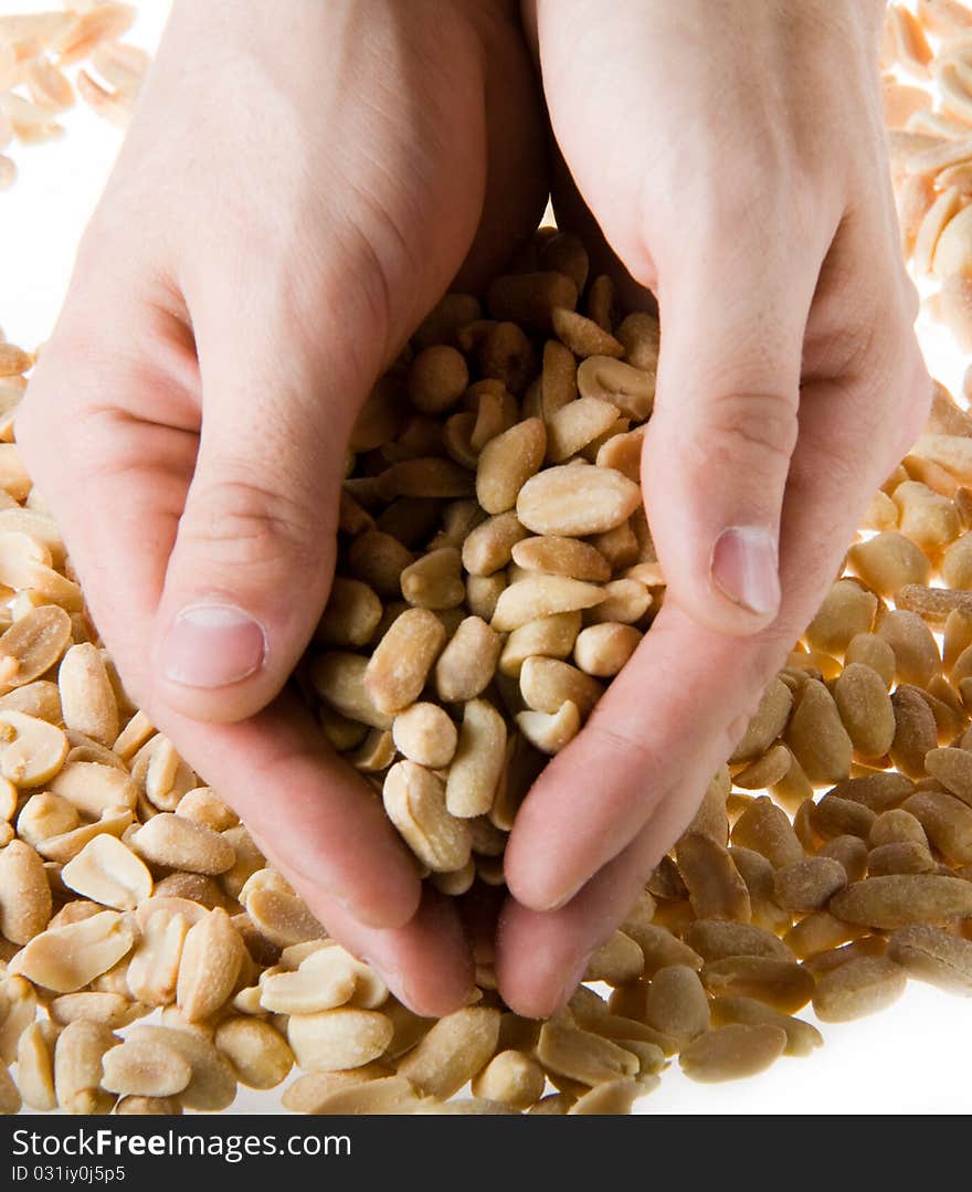 Hand holding a handful of salted peanuts