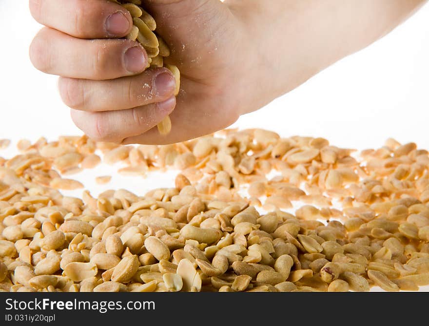 Hand holding a handful of salted peanuts