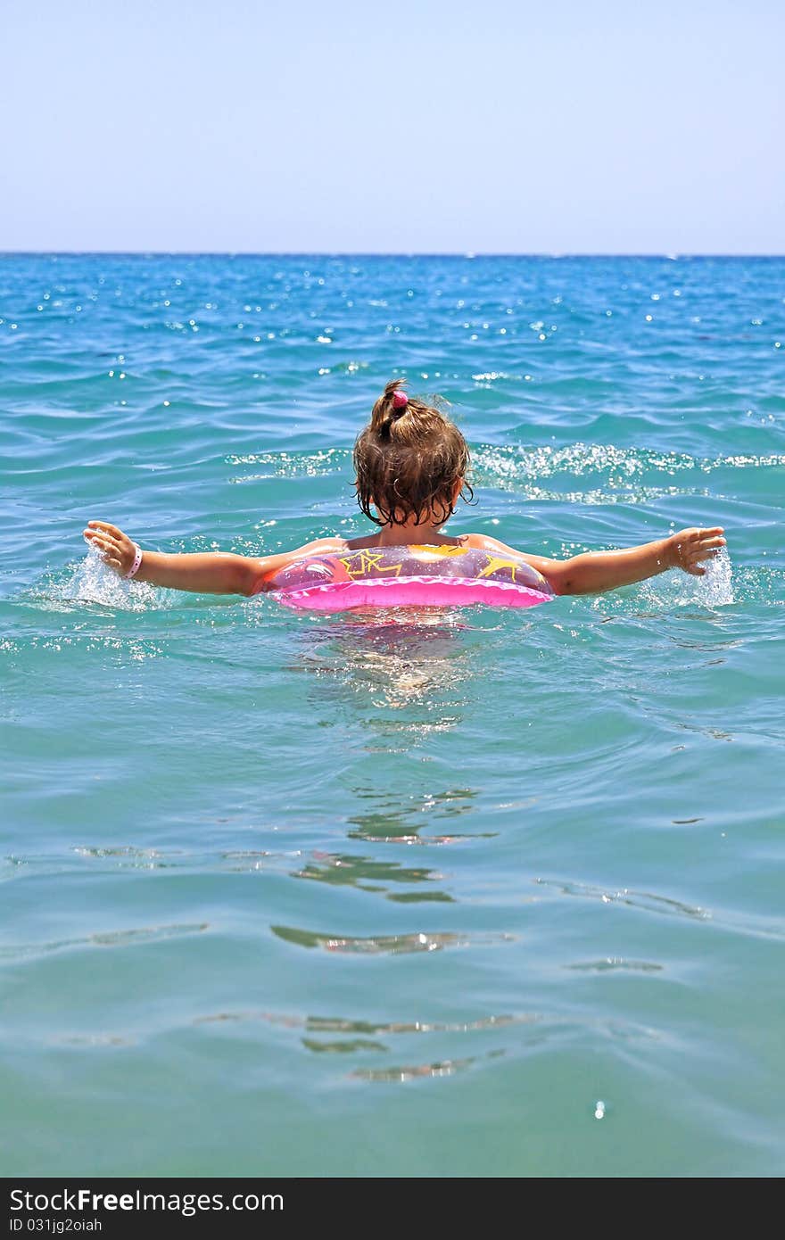 A little girl floating in a sea of pink wheel