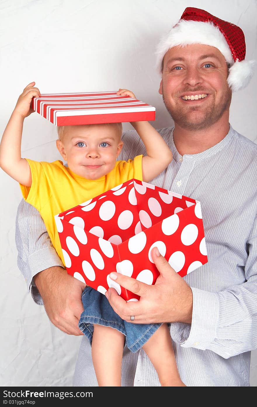 Baby boy with his father for Christmas holding a large gift box