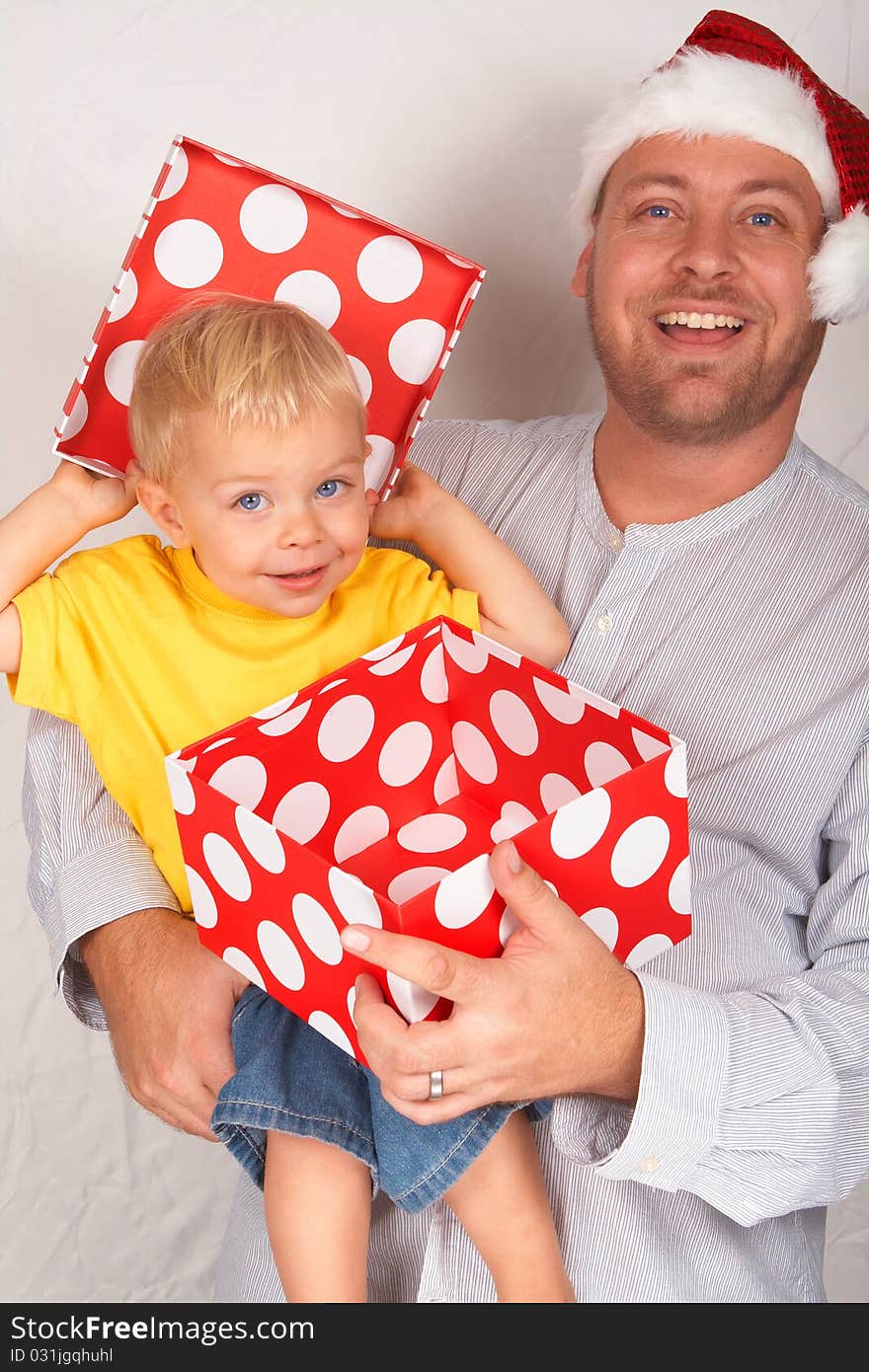 Baby boy with his father for Christmas holding a large gift box