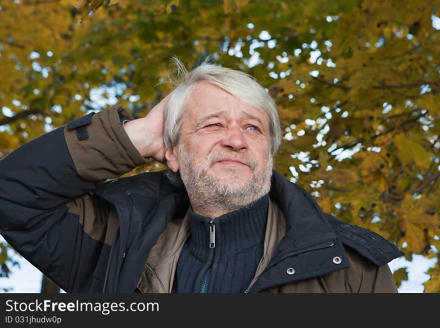 Portrait of mature thoughtful man with grey hair in autumn day. Portrait of mature thoughtful man with grey hair in autumn day.