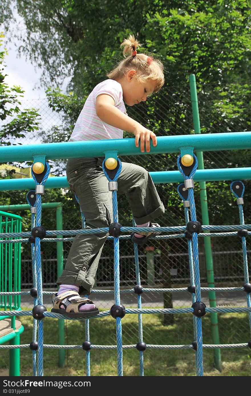 The four-year girl in an urban garden. A girl walking on the ladder on the playground. Spring - Summer 2010. The four-year girl in an urban garden. A girl walking on the ladder on the playground. Spring - Summer 2010