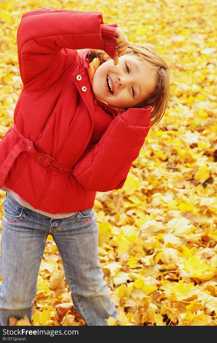 Autumn fun in the park. The girl makes grimaces.