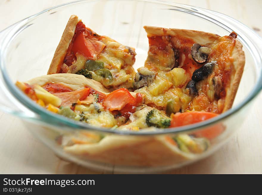 A slice of hot, fresh pizza being served in a bowl. A slice of hot, fresh pizza being served in a bowl.