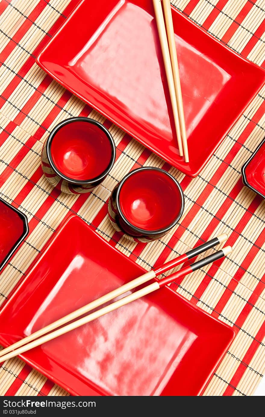 Red and black empty sushi set on the bamboo background. Red and black empty sushi set on the bamboo background