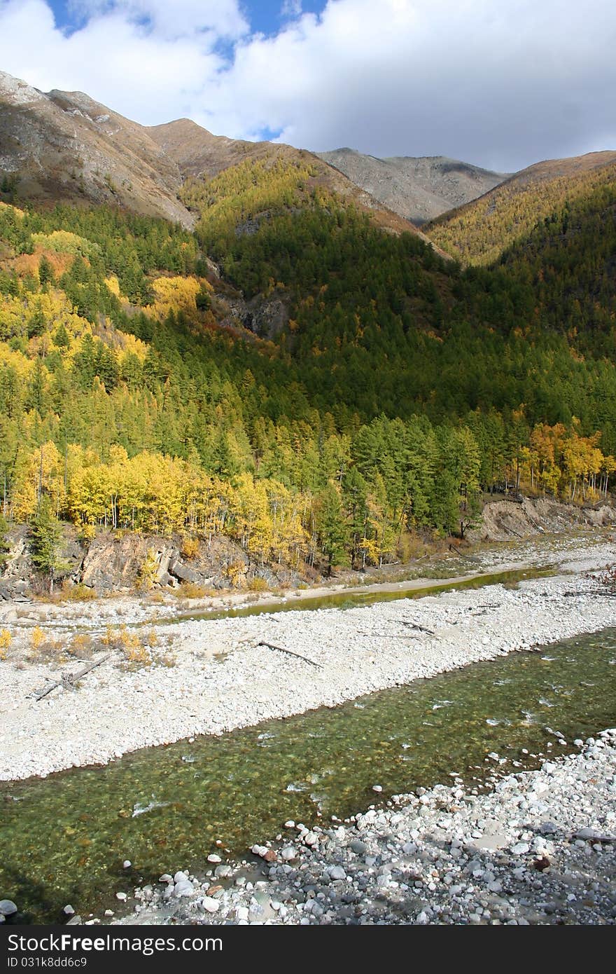 River at the foot of the autumn mountains