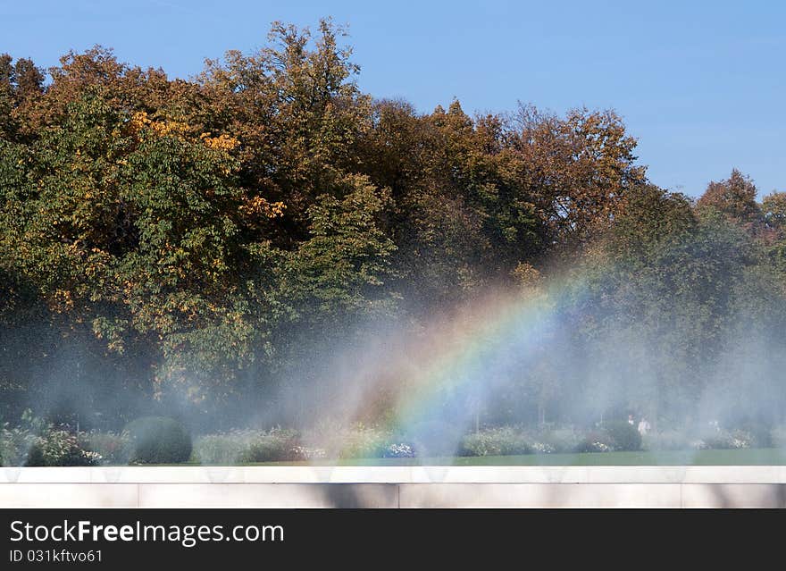 Rainbow Fountain in the background of green trees