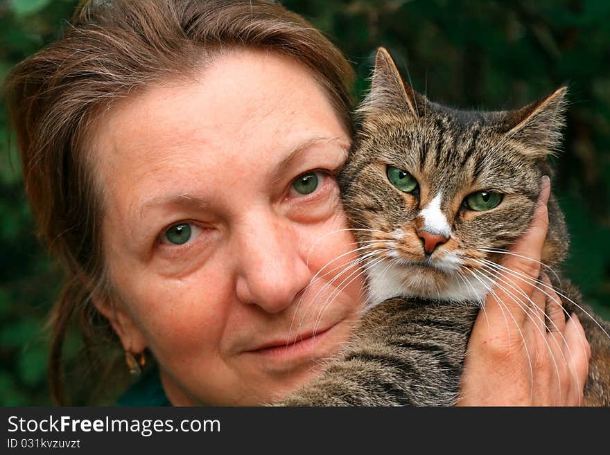 Portrait of a woman and a cat with green eyes.