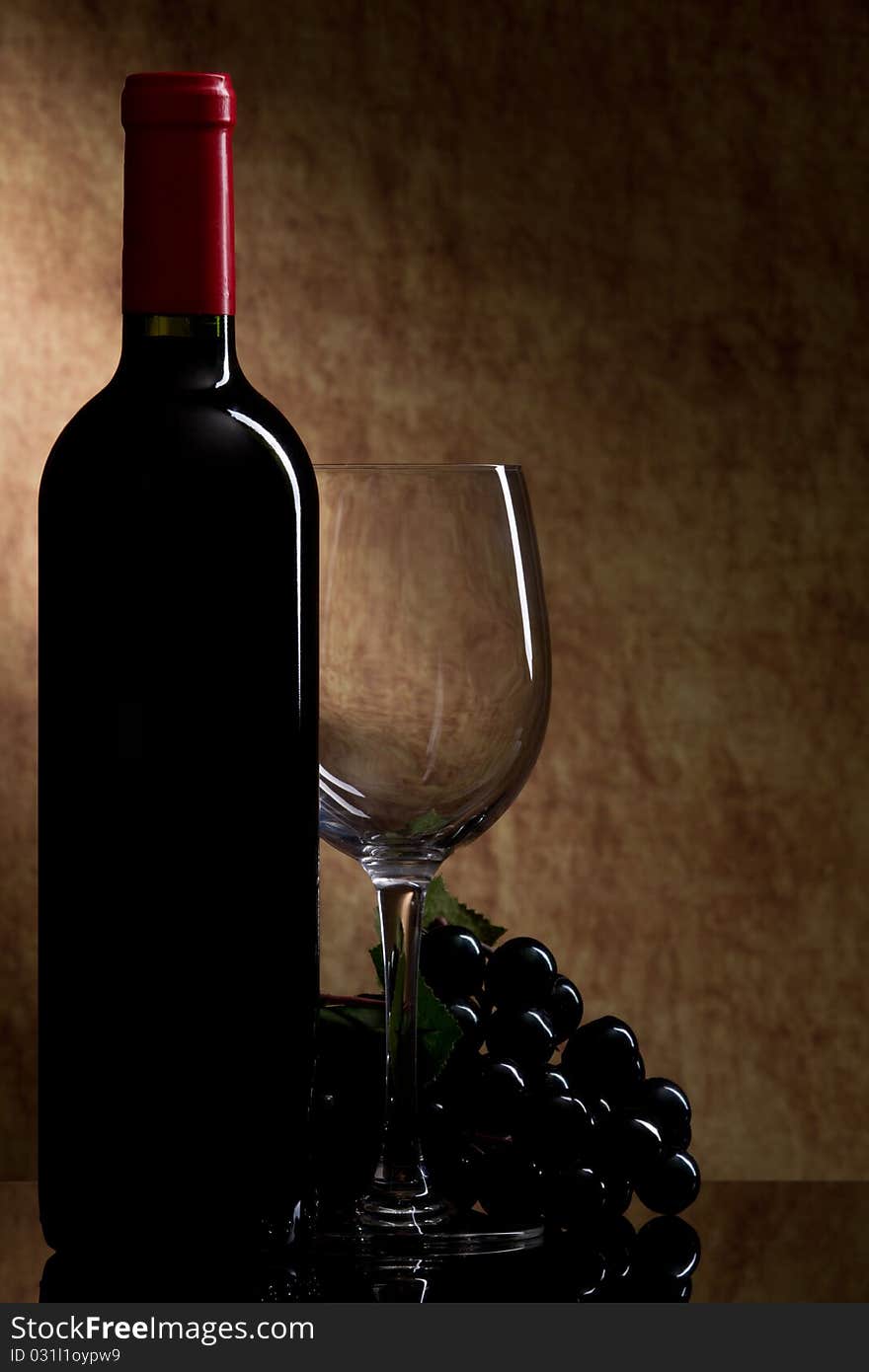 Bottle with red wine and glass and grapes