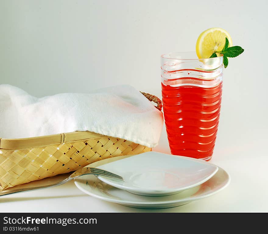 Cherry juice in a glass with a lemon on a white background. Cherry juice in a glass with a lemon on a white background