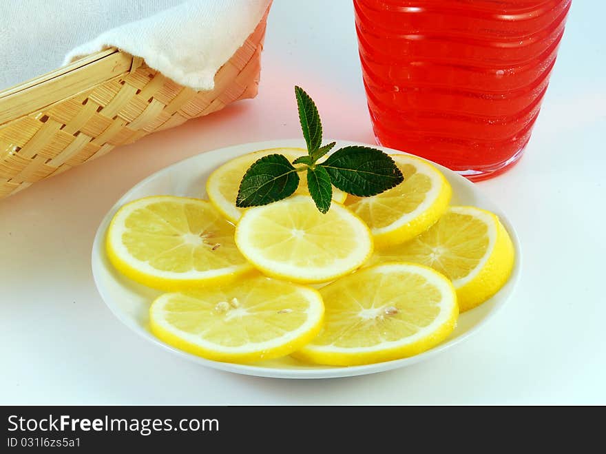 Cherry juice in a glass with a lemon on a white background. Cherry juice in a glass with a lemon on a white background