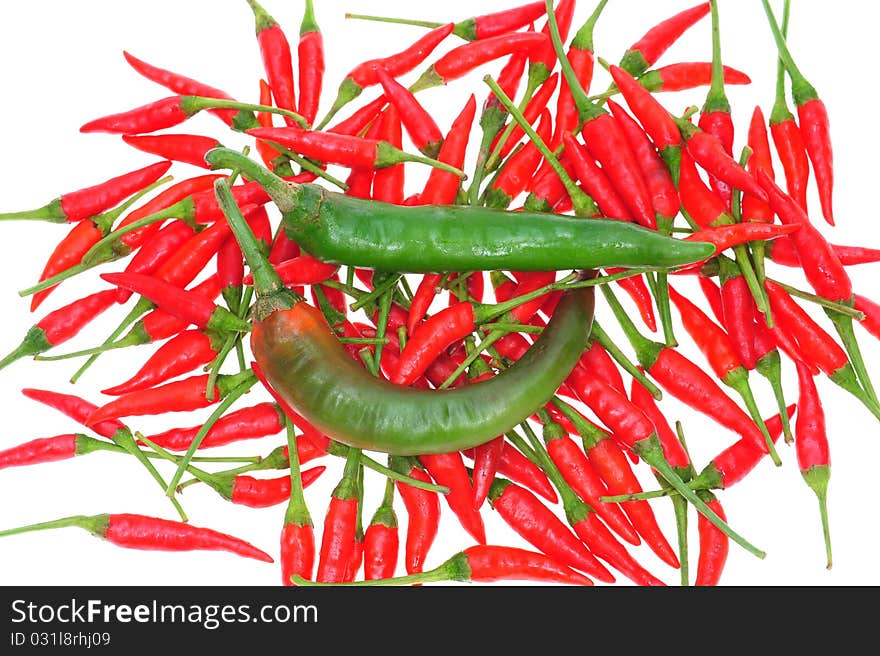 Green Chili On A Background Of Small Red Chili. Green Chili On A Background Of Small Red Chili