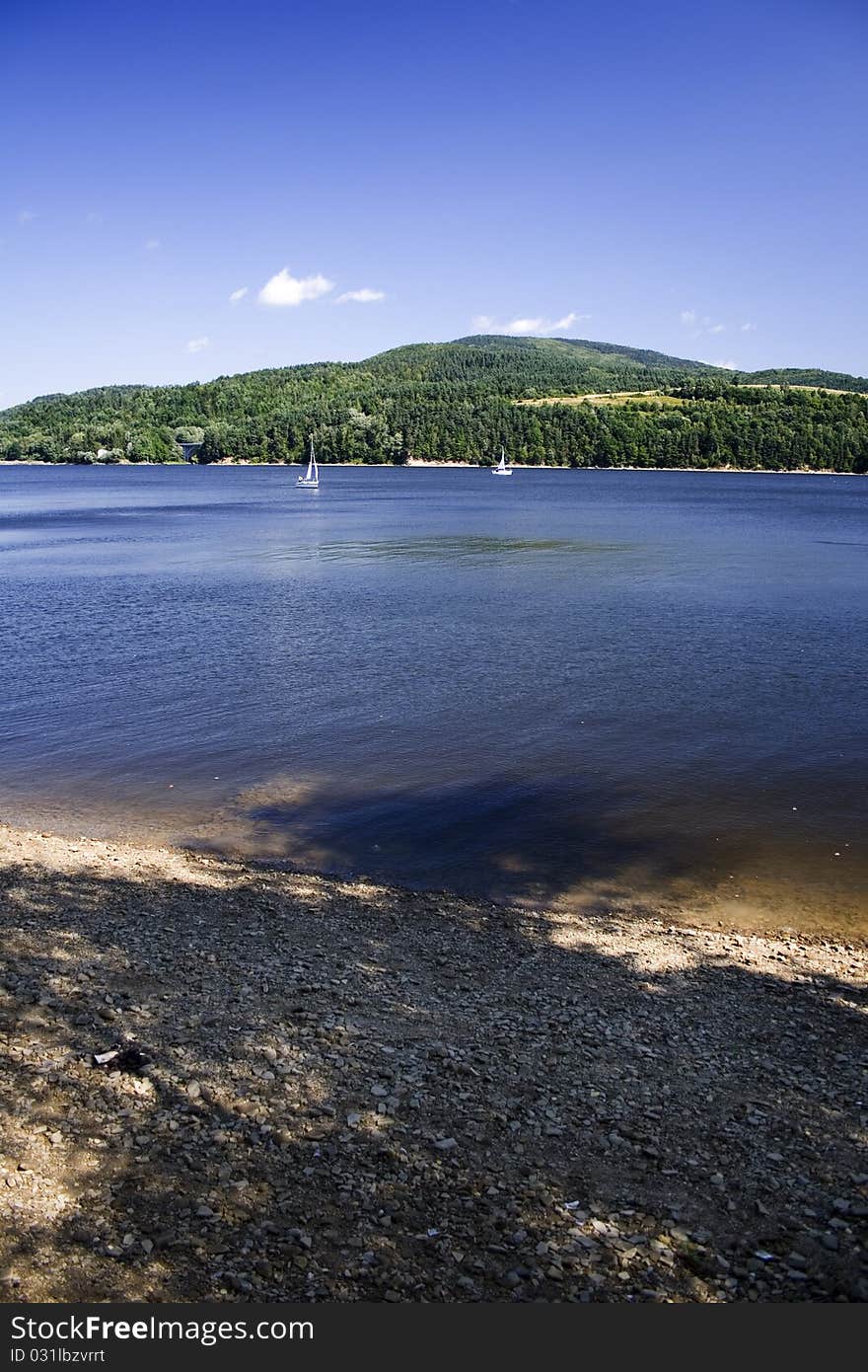 Beautiful lake located between the mountains on which you can sail. Beautiful lake located between the mountains on which you can sail.