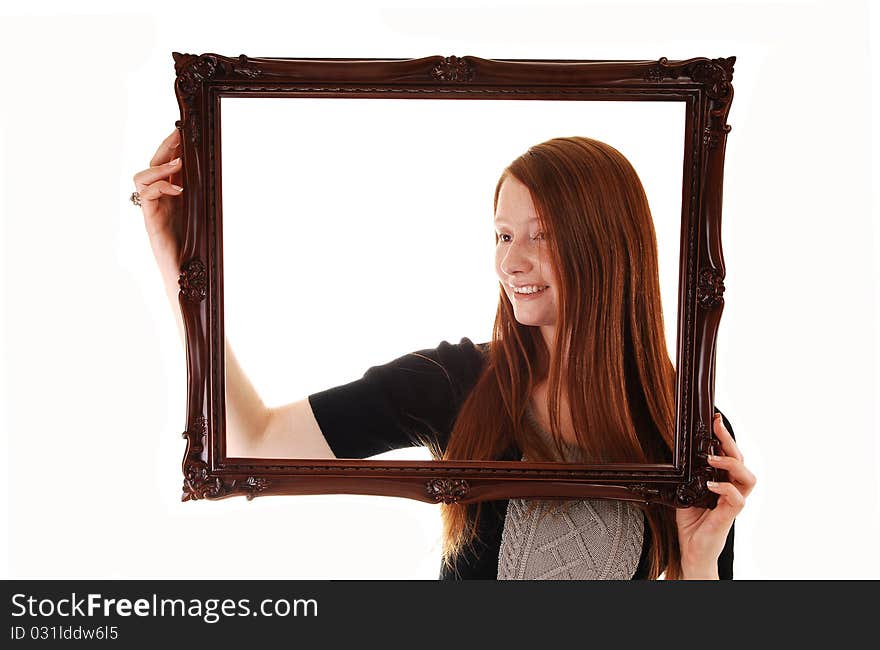 An young woman with long red hair holding a picture frame, in a black dress, with empty copy space in the frame, on white background. An young woman with long red hair holding a picture frame, in a black dress, with empty copy space in the frame, on white background.