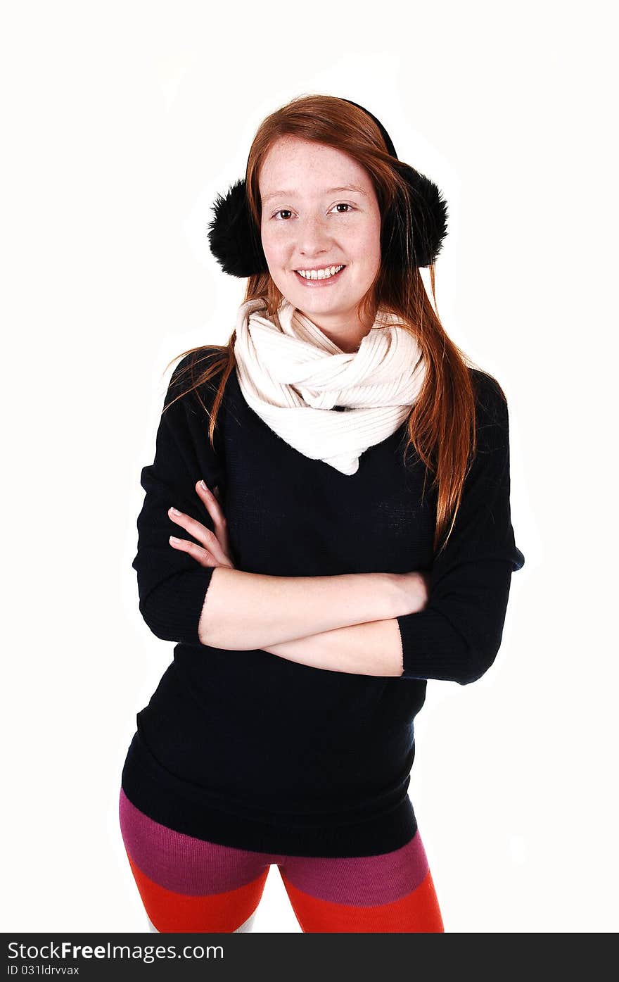 The portrait of a young woman with long red hair and ear cups and white scarf and and black sweater smiling into the camera, over white. The portrait of a young woman with long red hair and ear cups and white scarf and and black sweater smiling into the camera, over white.