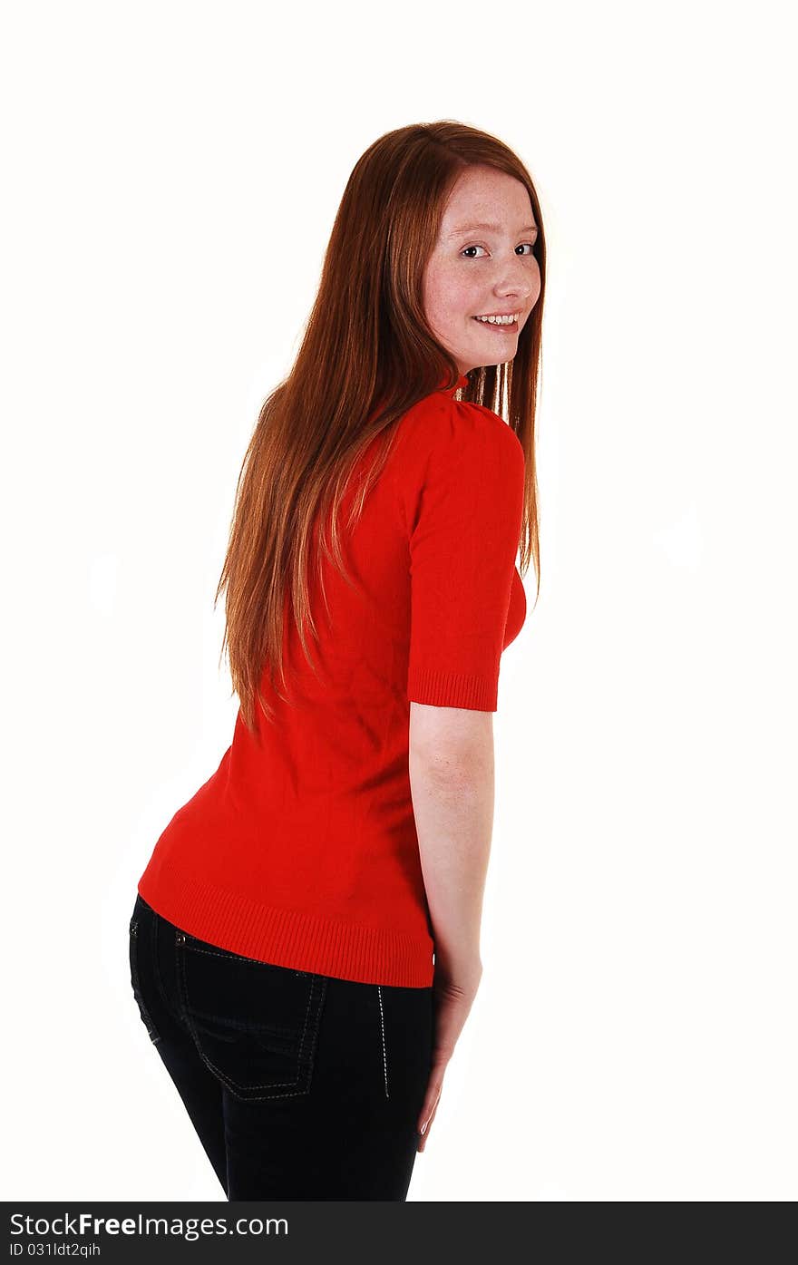 A young cute woman standing from the back, looking over her shoulder in a red sweater and jeans, with long red hair, for white background. A young cute woman standing from the back, looking over her shoulder in a red sweater and jeans, with long red hair, for white background.