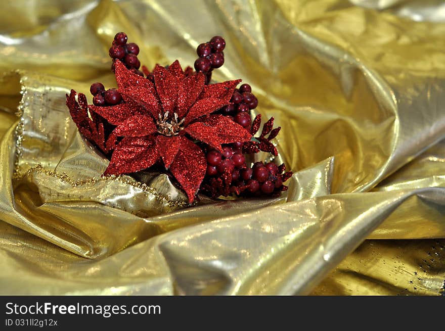 Abstract background of brilliant golden silk cloth with red christmas flower. Abstract background of brilliant golden silk cloth with red christmas flower