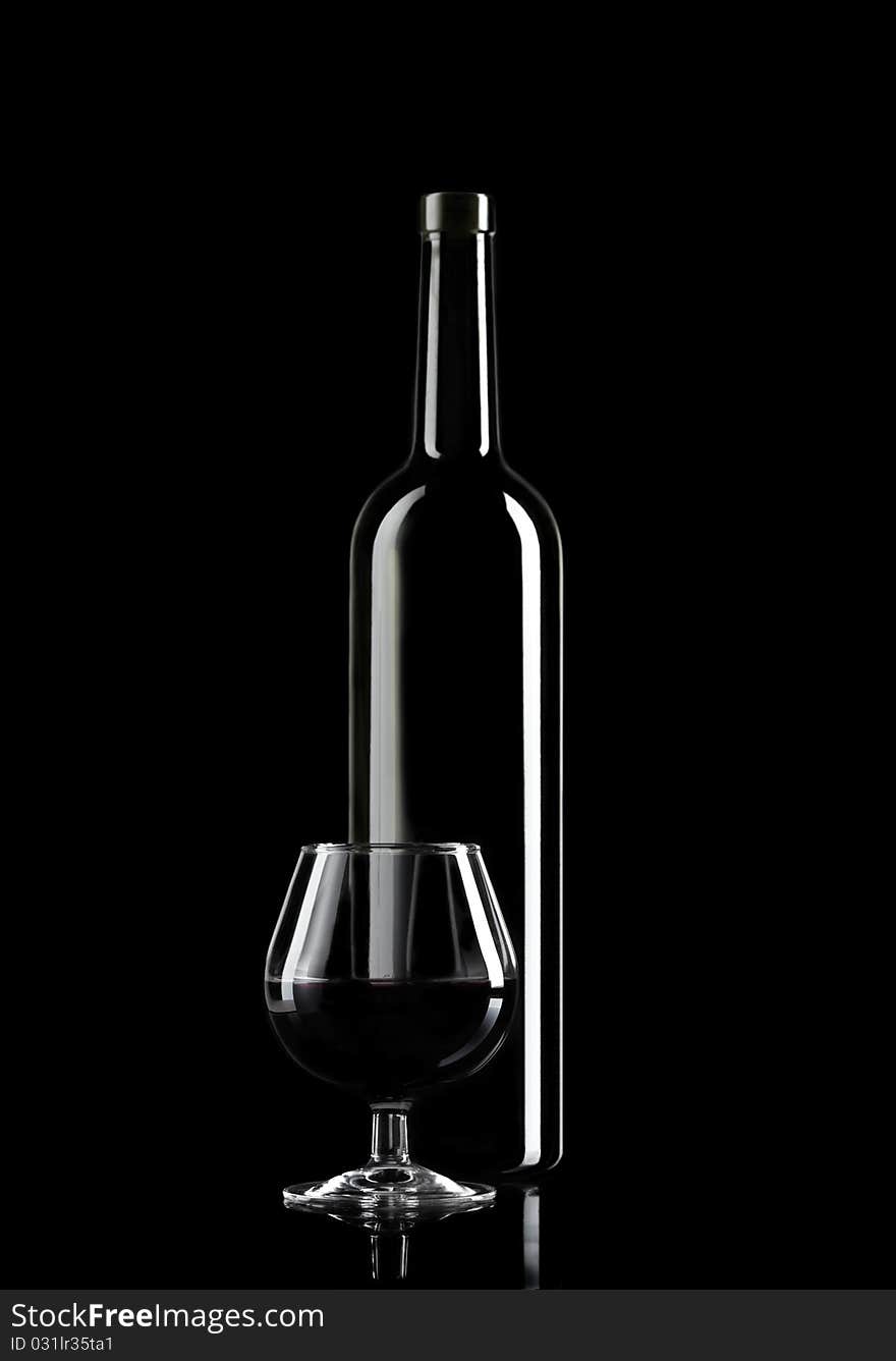 Glass of Wine and Wine Bottle on dark background