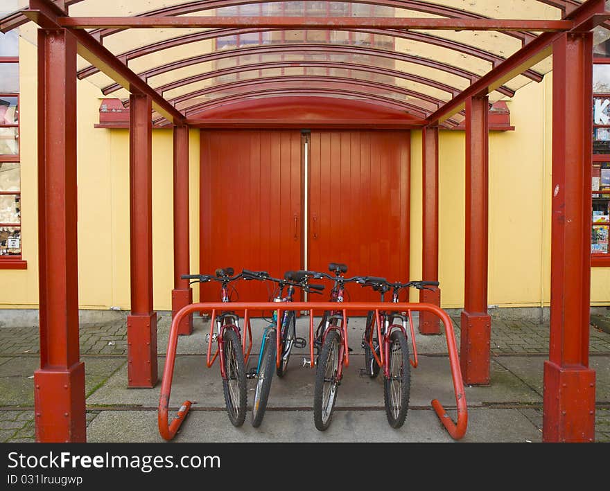 A row of commuter bikes parked against a vibrant backdrop. A row of commuter bikes parked against a vibrant backdrop.